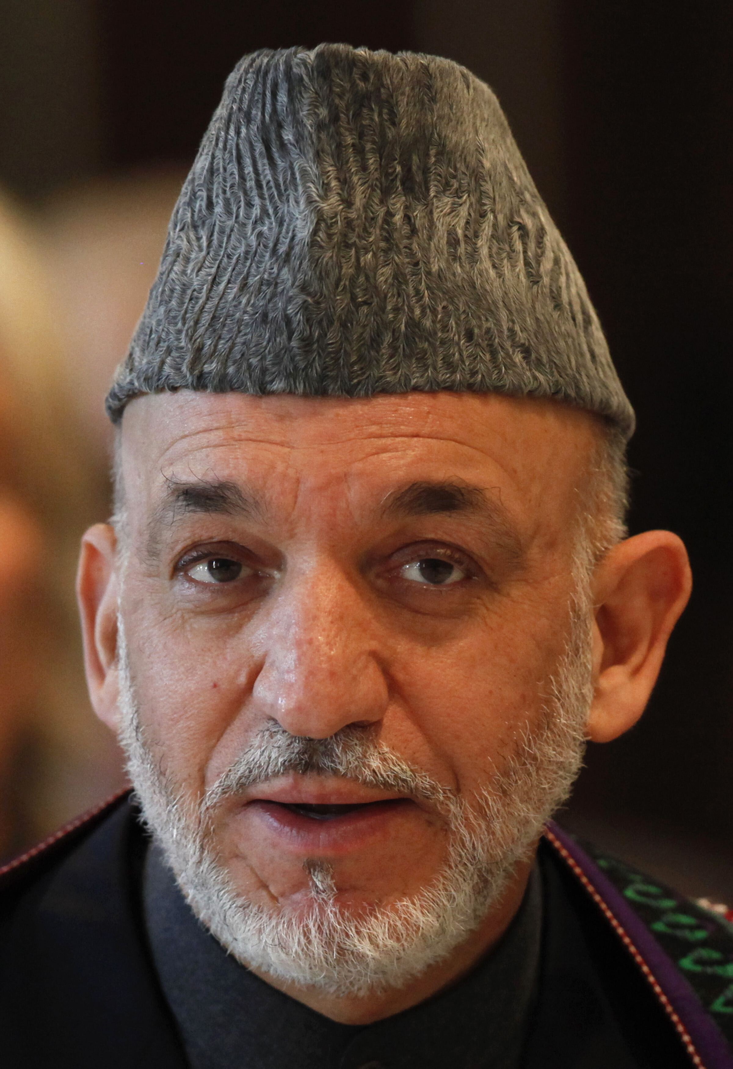 Portraitfoto von Hamid Karsai, der frontal in die Kamera schaut und einen Hut trägt.