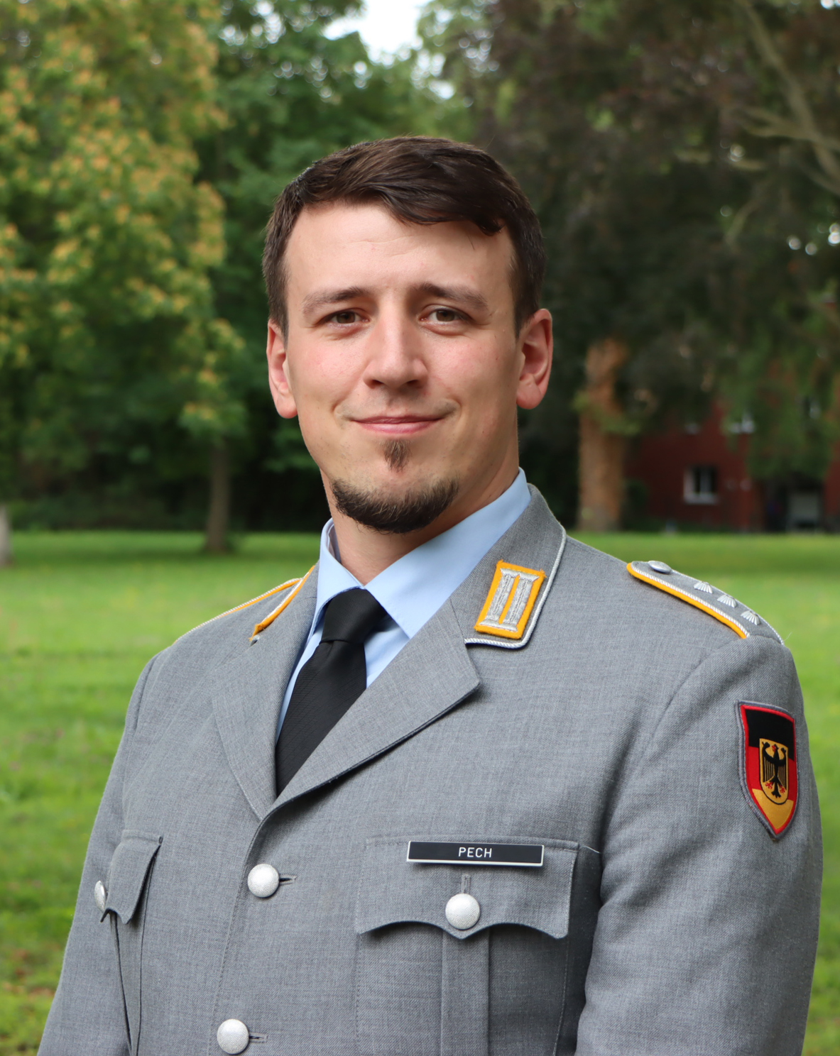 junger Mann in Uniform lächelt freundlich in die Kamera