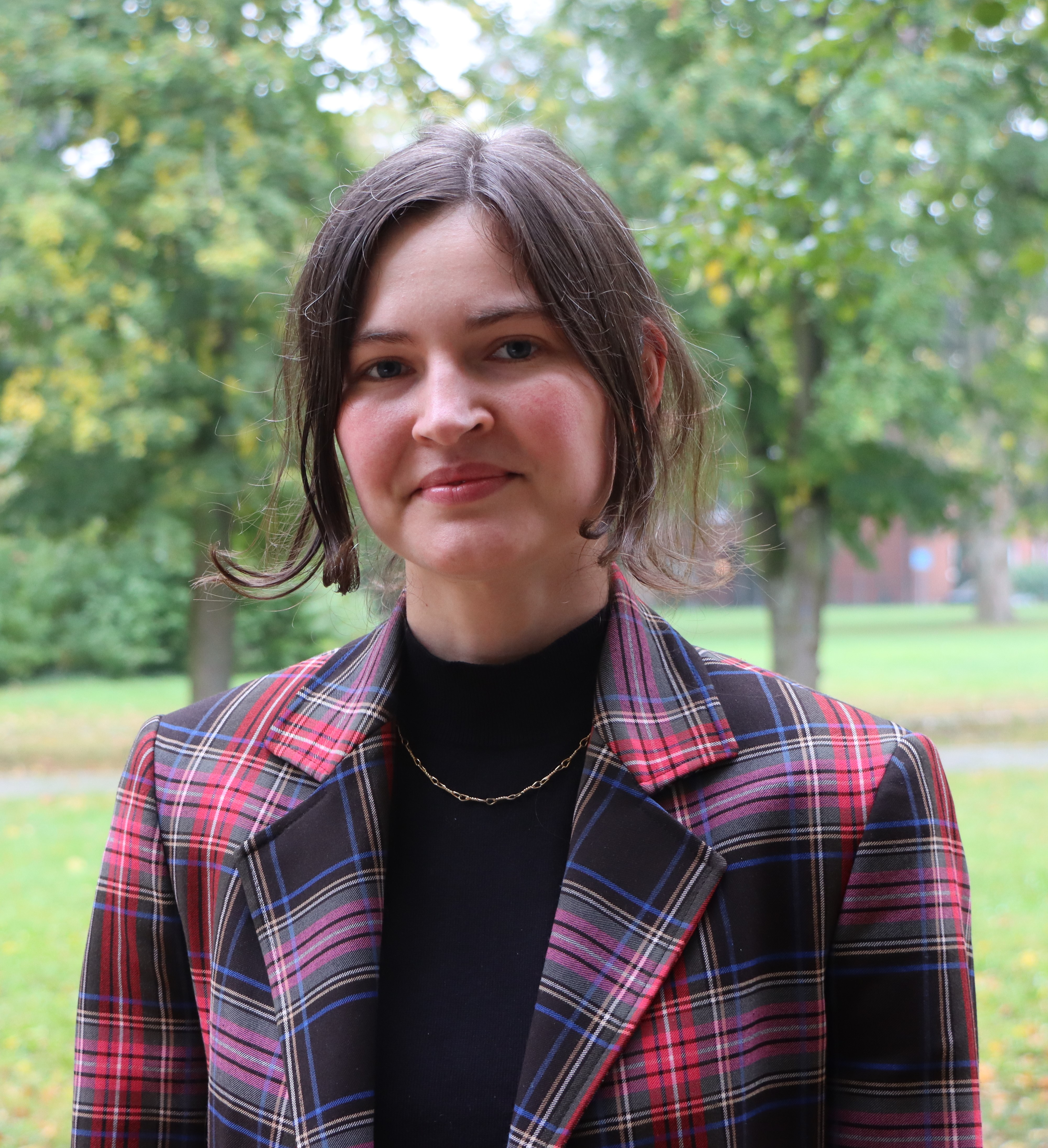 junge Frau lächelt freundlich in die Kamer