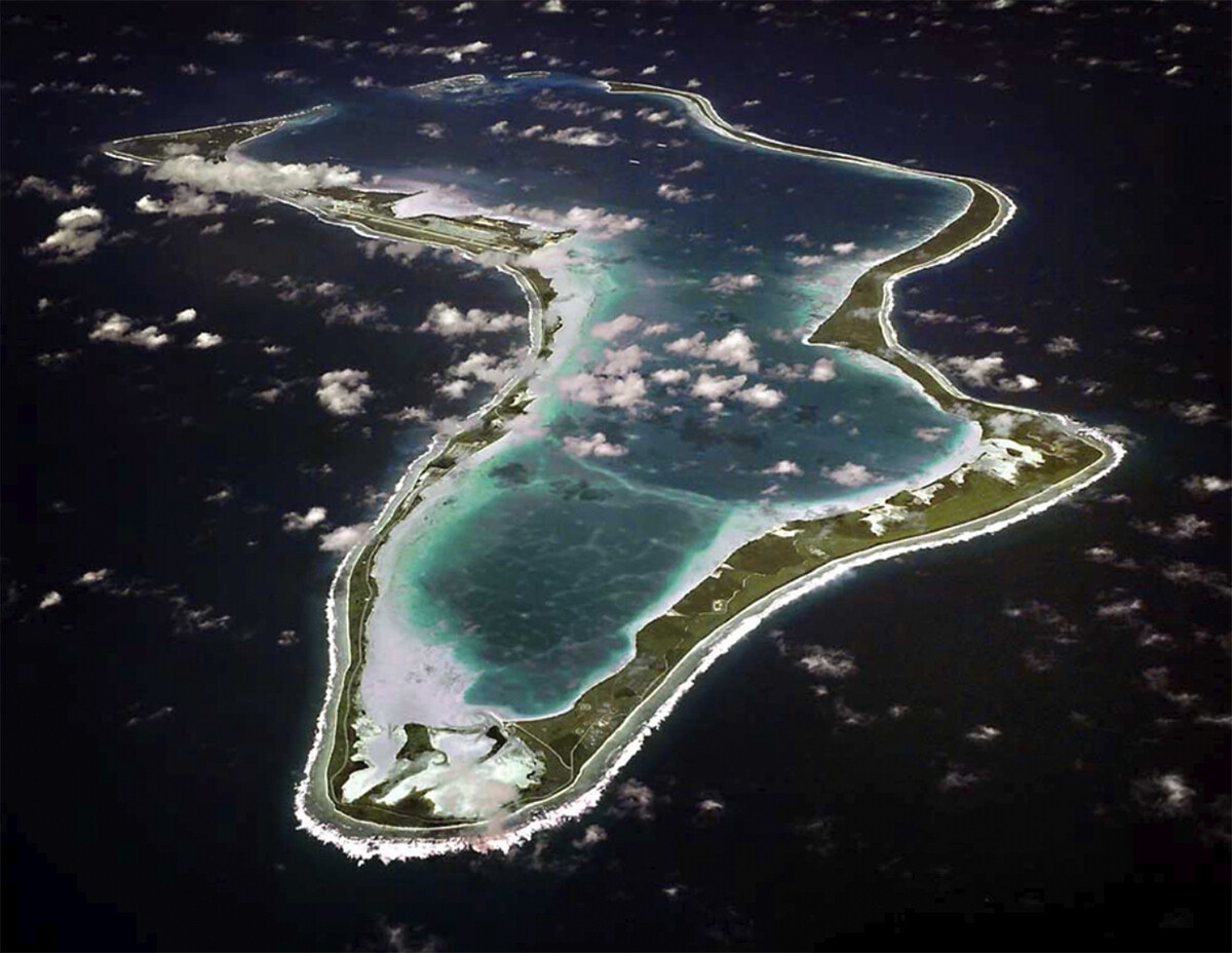 Luftansicht auf das mitten im Meer gelegene Atoll Diego Garcia, das kaum Landmasse hat.