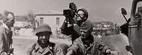 Fallschirmjäger und ein Kameramann einer Propagandakompanie nach der Landung auf Kreta 1941