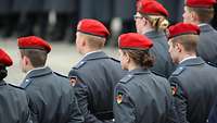 Soldaten (von hinten gesehen) stehen in Reihen nebeneinander