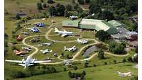 Luftbildansicht auf das Aussengelände mit mehreren Flugzeugen auf der Wiese