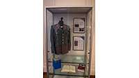 Vitrine mit 5 Büchern , 2 Tafeln und Uniformjacke