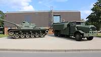 Kampfpanzer und Lastkraftwagen vor einem Gebäude