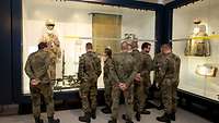 Soldaten stehen interessiert vor Museumsvitrinen