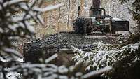 Ein mit Tarnnetz bedeckter Panzer "Puma" in einem verschneiten Wald