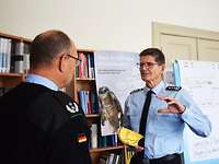 Colonel Hartmann with a yellow book (Handbuch IF 1957) in his hand talking to a lieutenant colonel
