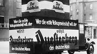 Fahrzeug mit Wahlkampfplakaten. Aufschrift: „Wer die echte Volksgemeinschaft will, der wählt Duesterberg den deutschen Mann.“