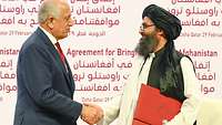 Vertreter der USA und der Taliban schütteln sich die Hand anlässlich der Unterzeichnung des Friedensabkommens 2020
