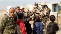 Deutsche Soldaten im Kontakt mit afghanischen Jugendlichen und Kindern.
