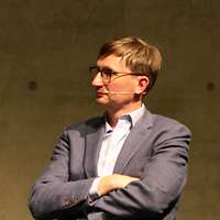 braunhaariger Mann mit Brille, Hemd und Sakko