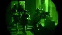 Soldaten des Kommando Spezialkräfte dringen während einer Übung in Dunkelheit in einem Haus vor
