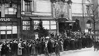 Lange Schlange von Wartenden, unter ihnen erstmals auch Frauen, stehen vor einem Wahllokal in Berlin im Januar 1919.