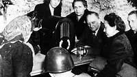 Menschen in einem Keller vor einemRradio, NS-Propaganda Motiv, Mai 1944