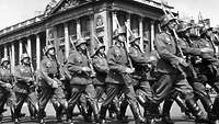Deutsche Soldaten marschieren in Formation vor der Militärkommandantur in Paris.