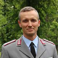 Mann mittleren Alters in Uniform lächelt in die Kamera