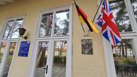 Tür im Eingangsbereich mit deutscher und britischer Flagge an der Wand