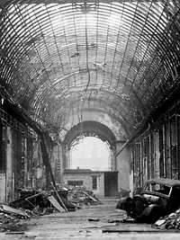 Zerstörte Einkaufspassage, Berlin 1945, Trümmer und ein Autowrack, helles Licht im Bogen am Ende