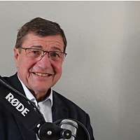 Ein Mann im Anzug und ein Mann in Uniform im Tonstudio vor einem Mikro