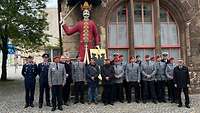 Militär in Uniform vor einer Statue