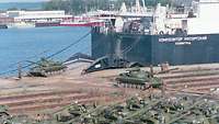 russische Panzer vor einem Frachtschiff