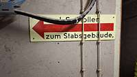 Fluoreszierendes Hinweisschild zu einem Luftschutzstollen in einer Kaserne in Deutschland