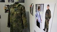 Eine Feldjacke in Flecktarn mit Aussparung im Bauchbereich auf einem Torso einer Puppe