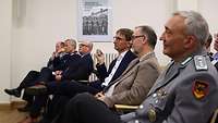 6 ältere Männer sitzen in der ersten Reihe und folgen gespannt dem Vortrag
