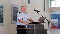 Mann in Uniform stehend am Rednerpult