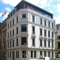 Weißes Eckgebäude mit Flagge der Freien- und Hansestadt Hamburg