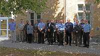 Eine Gruppe von Männern und eine Frau haben sich zu einem gemeinsamen Foto aufgestellt