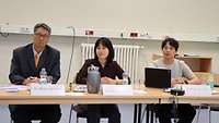 Eine Frau und zwei Männer aus Süd-Korea