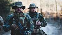 Zwei Männer in Uniformen nehmen an einem Airsoft-Spiel teil.